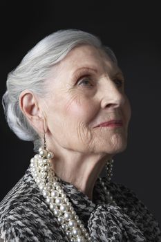 Senior Woman with Pearl Earrings looking up
