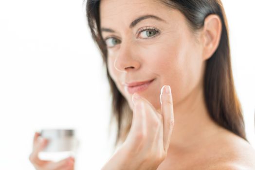 Woman in her forties applying  face cream