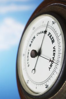 Closeup of weather barometer over blue background