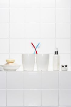 Still life of pair of toothbrushes conveying togetherness in white bathroom