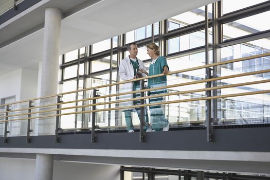 Male and female physicians talking on the balcony