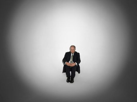 Middle aged businessman sitting in spotlight
