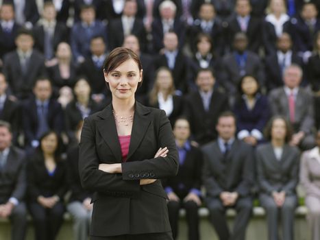 Business woman standing in front of business people sitting in bleachers portrait