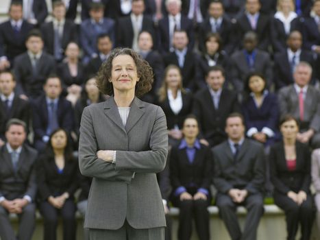 Business woman standing in front of business people sitting in bleachers portrait