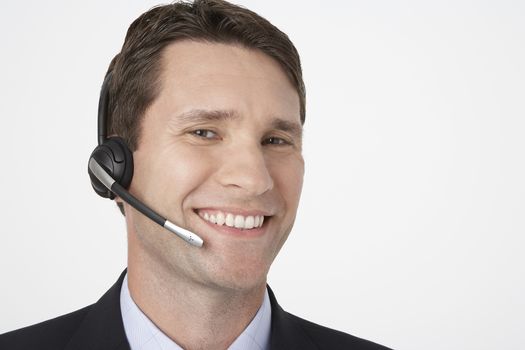 Closeup portrait of happy male telephone operator over white background