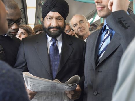 Commuter in turban Reading paper on Train
