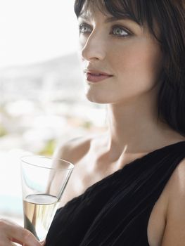 Closeup of a beautiful young woman with champagne glass outdoors