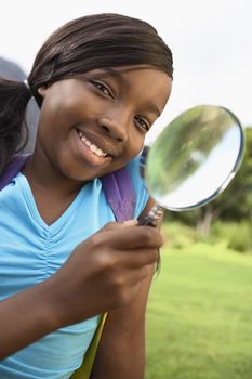 Portrait of an African American girl using magnifying glass