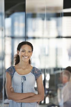 Portrait of smiling young businesswoman with colleague working in background