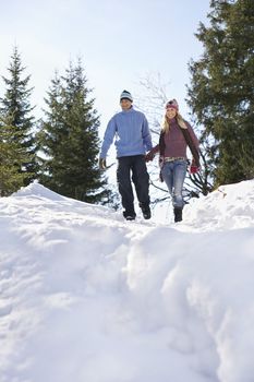 Couple descending snow-covered hill low angle view
