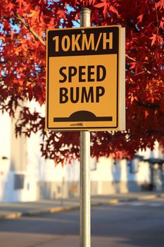 Speed bump road sign with building background