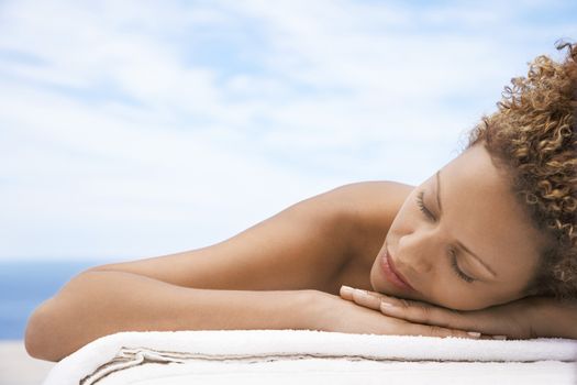 Woman lying on massage table head and shoulders eyes closed