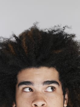 Young man with afro  looking up high section