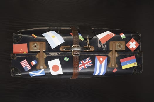 Suitcase with various flag stickers studio shot