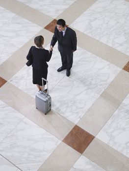 Elevated view of a businessman and businesswoman shaking hands on tiled floor