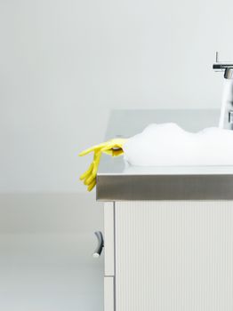 Closeup of yellow rubber gloves on edge of sink