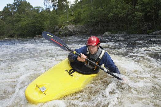 View of a young man kayaking in river