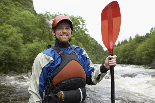 Man holding kayak oar by river portrait