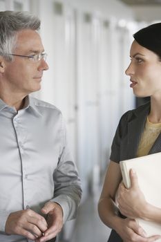 Businessman and female colleague talking in office