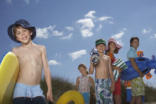 Portrait of smiling parents and three children with beach accessories