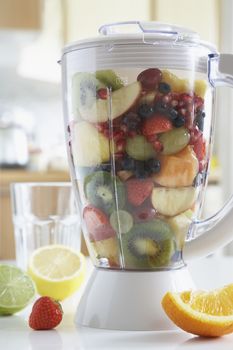 Blender filled with fresh fruits close-up