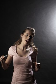 Young woman with mp3 player singing in studio