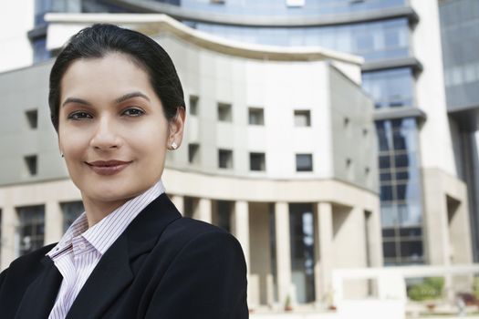Closeup portrait of beautiful young businesswoman in front of buildings