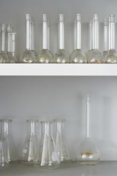 Scientific flasks displayed in shelves at laboratory