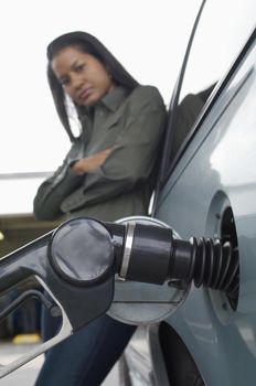 Woman leaning on van with fuel pump