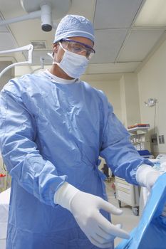 Male surgeon in protective workwear preparing for operation
