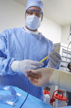 Male surgeon making preparation before a surgery in operating room