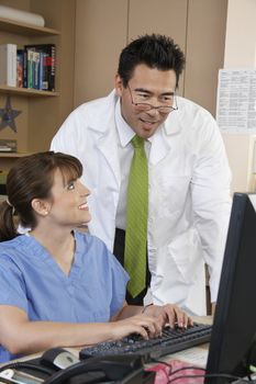 Nurse and doctor working on computer