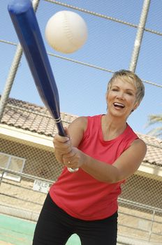 Happy Caucasian woman playing baseball