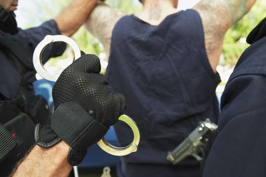 Cropped image of policemen arresting criminal