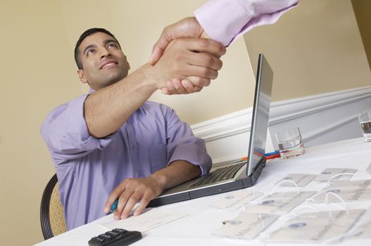 Happy businessman shaking hand with colleague