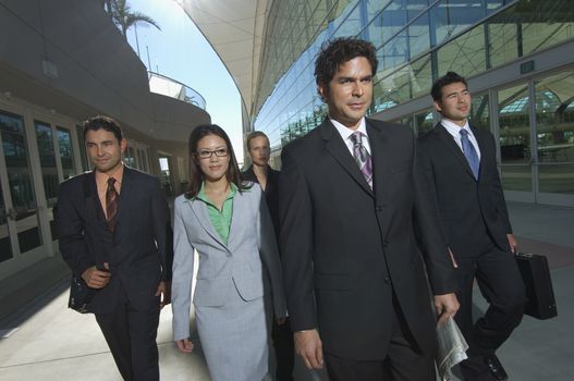 Group of business people walking past office building