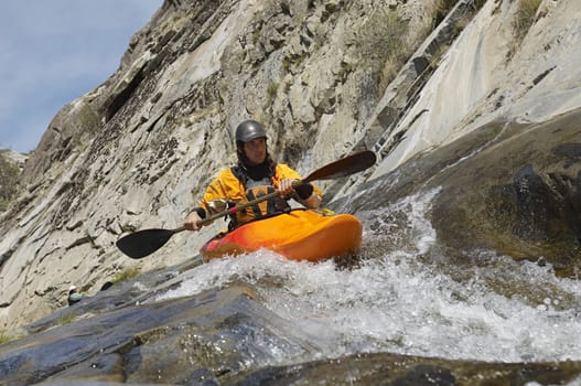 Caucasian man kayaking in mountain river