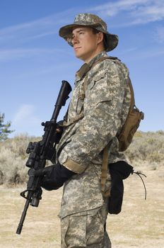 American soldier in army camouflage uniform holding rifle