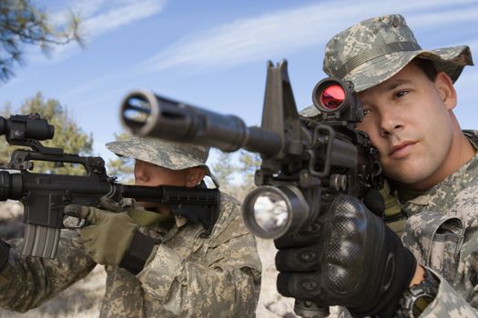 Two US army soldiers aiming with machine guns on a mission