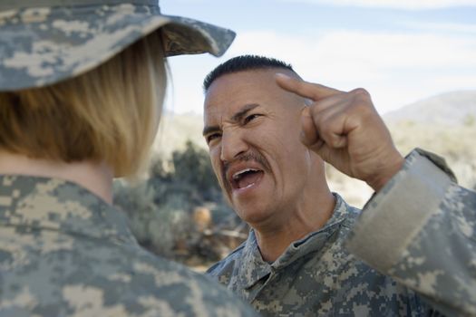 Military officer shouting at female soldier during a training session