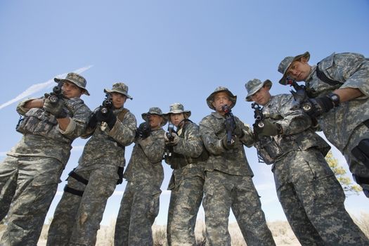 Group portrait of soldiers aiming guns