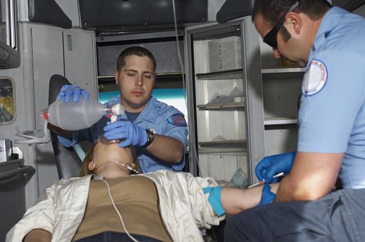 Paramedics taking care of female victim in ambulance