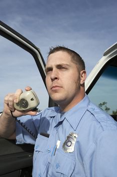 Portrait of a male paramedic using CB radio by vehicle