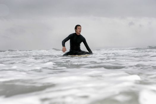 Young man on surfboard in ocean