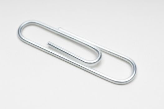 Closeup of steel paperclip isolated over white background