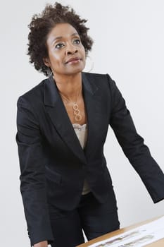 An African American businesswoman leaning on table
