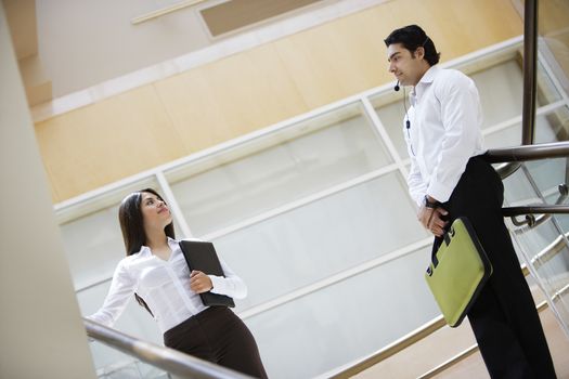 Business woman and business man talking on stairs