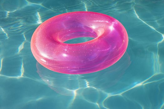 Pink inflatable tube floating in swimming pool