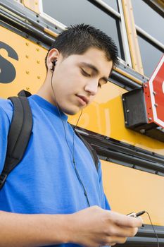 High School Boy With MP3 Player by School Bus