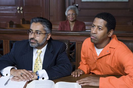Lawyer and criminal sitting in court